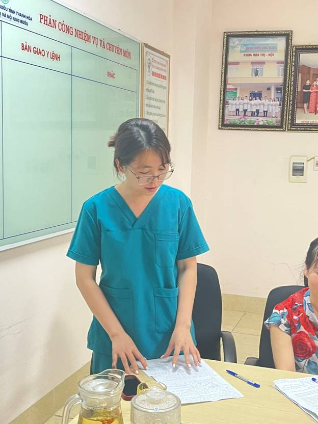 A person in a blue scrubs standing at a table

Description automatically generated