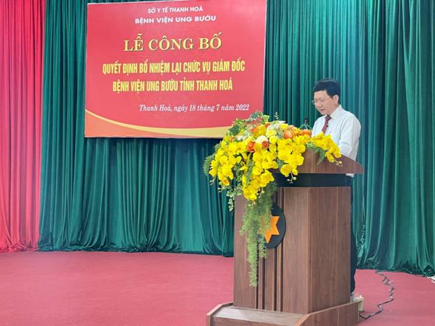A person standing behind a podium with flowers on it

Description automatically generated with medium confidence