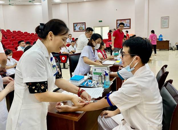 A person and person in white scrubs getting blood shot

Description automatically generated